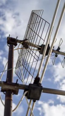 Gökyüzü ve bulutların zaman çizelgesi. Ön planda dikey televizyon antenleri var.