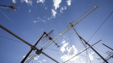 Gökyüzünün zaman çizelgesi ve ön planda televizyon anteni olan bulutlar. 