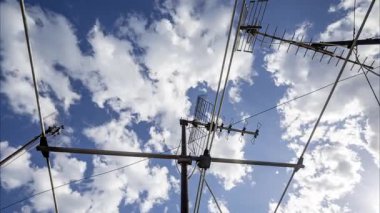 Gökyüzünün zaman çizelgesi ve ön planda televizyon anteni olan bulutlar. 