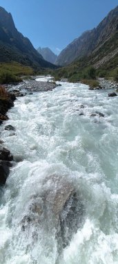 Dağlarda akan nehri olan güzel bir manzara.