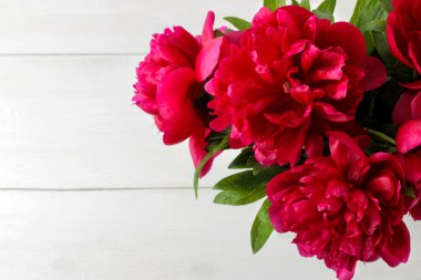 Beyaz ahşap arka plan üzerinde güzel parlak pembe şakayık çiçeklerçerçeve. üst görünüm. metin için alan