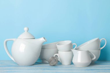 many different utensils. Tableware on a blue background. Clean tableware. various plates, bowls and cups.