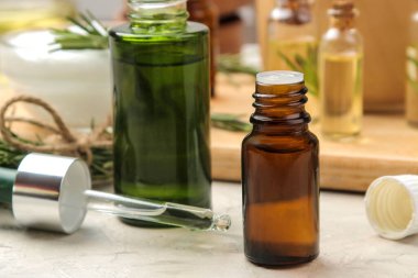 Cam bir şişede doğal biberiye yağı ve arka planda taze bir biberiye filizi. Yüz ve vücut bakımı. spa.