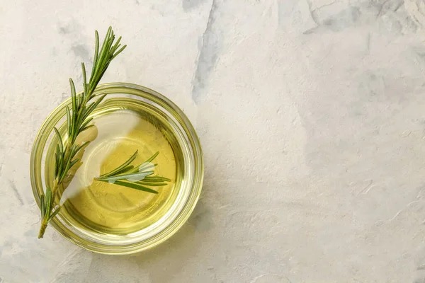 Stock image Natural rosemary essential oil in a glass bottle and a fresh sprig of rosemary on a light background. face and body skin care. spa.