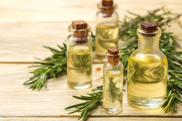 stock image Natural rosemary essential oil in a glass bottle and a fresh sprig of rosemary on a light background. face and body skin care. spa.