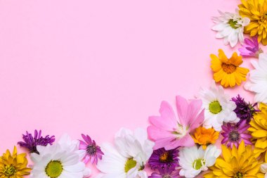Çerçeve şeklinde narin pembe bir zemin üzerinde çeşitli yaz çiçeklerinden oluşan bir buket.
