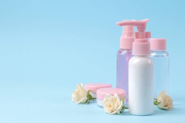 krema, süt ve vücut losyonu mavi arka planda gül özü, kişisel bakım için kozmetik, spa tedavileri