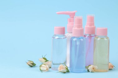 krema, süt ve vücut losyonu mavi arka planda gül özü, kişisel bakım için kozmetik, spa tedavileri