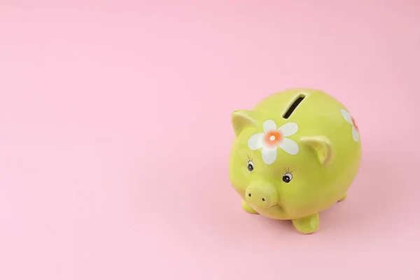 green pig piggy bank on pink background, money saving concept.