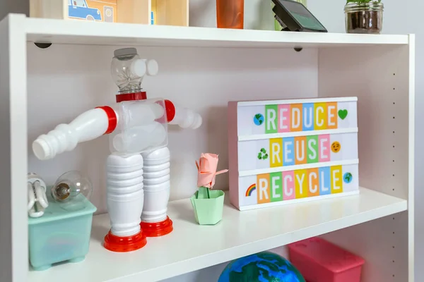关闭回收玩具机器人与塑料包装和轻箱与文字减少 重复使用 循环利用在架子上的课堂 生态教育概念 — 图库照片