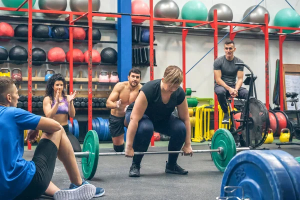 Crouched Vrouw Klaar Gewichten Tillen Terwijl Haar Sportschool Maten Juichen — Stockfoto