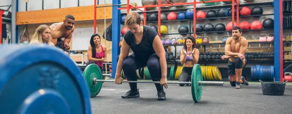 Geconcentreerde Vrouw Klaar Doen Gewichtheffen Terwijl Haar Sportschool Maten Juichen — Stockfoto