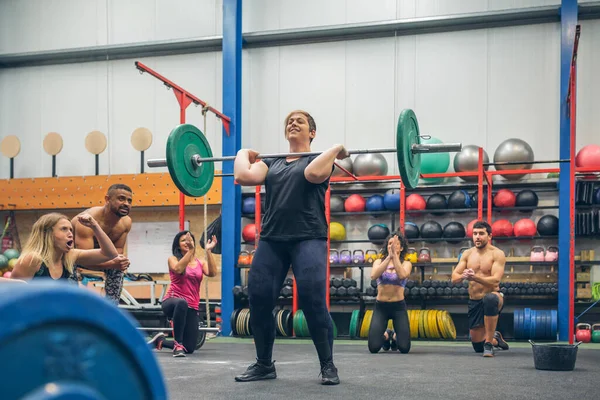 Stolt Leende Kvinna Tyngdlyftning Medan Hennes Gym Kompisar Hejar Henne — Stockfoto