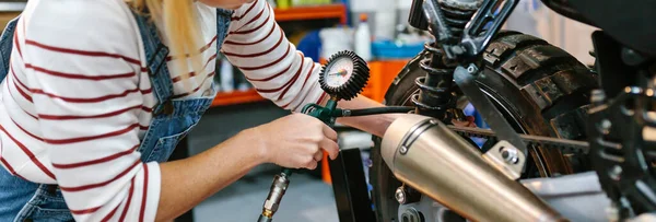 工厂内带压力计检测轮胎气压的无法辨认的机械师 — 图库照片