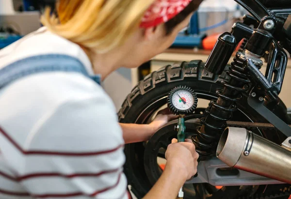 工厂内带压力计检测轮胎气压的无法辨认的机械师 — 图库照片