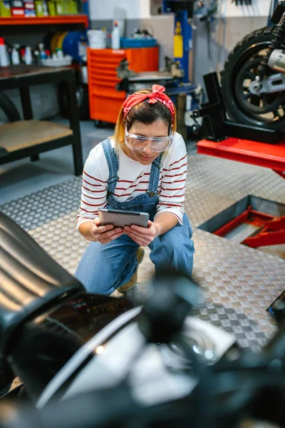 Soustředěná Žena Mechanik Bezpečnostními Brýlemi Drží Digitální Tablet Zatímco Přezkoumání — Stock fotografie