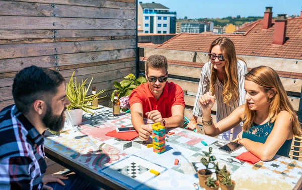 一群快乐的朋友在一个夏季派对的屋顶玩延加游戏时玩得很开心 — 图库照片