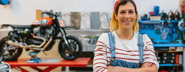 Portret Uśmiechniętej Mechaniczki Patrzącej Kamerę Stojącej Przed Platformą Motocyklem Fabryce — Zdjęcie stockowe