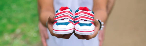 Oigenkännlig Gravid Kvinna Visar Små Baby Sneakers Medan Hennes Partner — Stockfoto