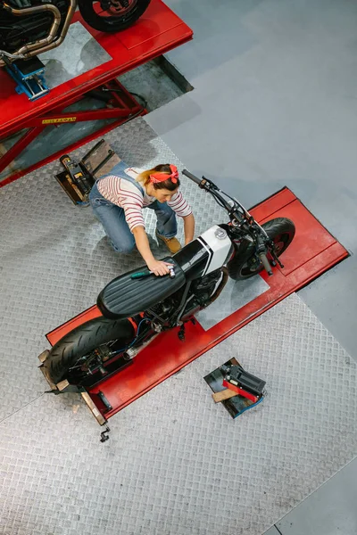 Widok Góry Mechanik Kobieta Przeglądając Niestandardowe Motocykl Platformie Fabryce — Zdjęcie stockowe