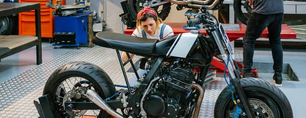 Kobieta Mechanik Sprawdzanie Niestandardowe Motocykl Garażu — Zdjęcie stockowe