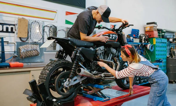 Équipe Couple Mécaniciens Examinant Moteur Moto Personnalisée Sur Plate Forme — Photo