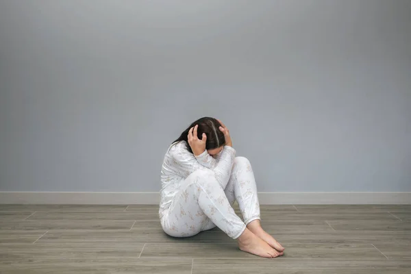 无法辨认的患有精神障碍和自杀念头的妇女双手托着头坐在地板上 — 图库照片