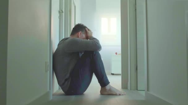 与患有精神障碍和自杀倾向的男性患者交谈的女精神病医生坐在走廊的房间地板上 — 图库视频影像