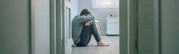 一个无法辨认的精神障碍患者坐在精神健康中心的房间地板上哭泣 — 图库照片