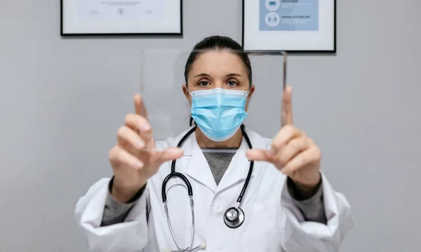 女性医師とともに保護マスクまっすぐ前に見て 透明タブレットを保持 — ストック写真