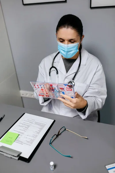 Ärztin Blickt Auf Transparentes Tablet Mit Medizinischer Digitaler Diagnose Auf — Stockfoto