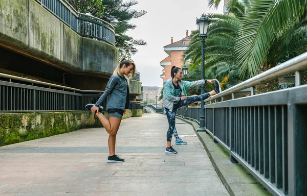 Grupo Mulheres Felizes Amigos Corredores Esticando Pernas Antes Treinar Cidade — Fotografia de Stock
