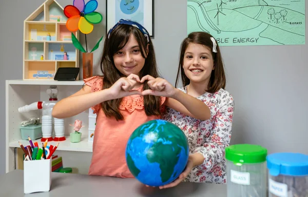 Dvě Šťastné Studentky Ukazující Ručně Vyrobenou Zeměkouli Zatímco Jedna Utvářela — Stock fotografie