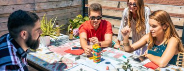 Bir grup mutlu arkadaş bir yaz partisinde çatıda Jenga oyunu oynarken eğleniyorlar.