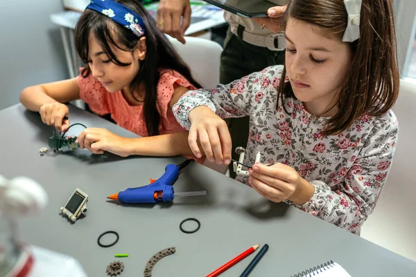 Konzentrierte Studentinnen Die Mit Ihrer Lehrerin Einem Robotikkurs Maschinenteile Zusammenbauen — Stockfoto