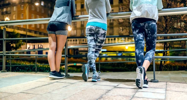 町の夜の訓練の後 禁止されている交差した足を持つ3人の認識できない女性ランナーのビューを待ちます — ストック写真