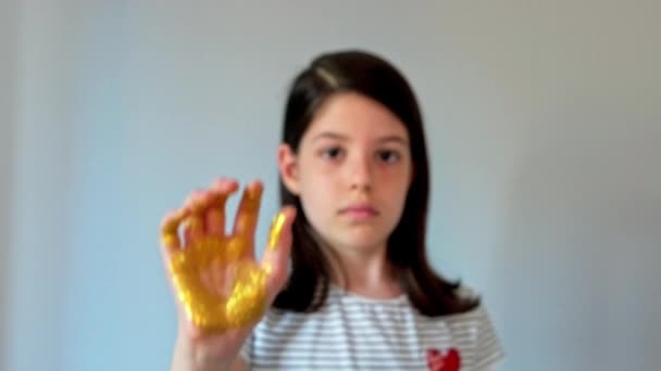Vážná Mladá Dívka Ukazující Svou Dlaň Zakrytou Zlatým Třpytem Zatímco — Stock video