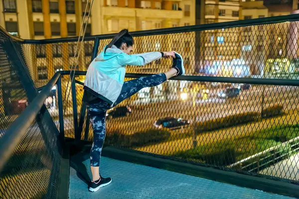 Tanımlanamayan Esmer Kadın Sporcu Geceleri Şehirde Koşmadan Önce Bacaklarını Köprü Telifsiz Stok Fotoğraflar
