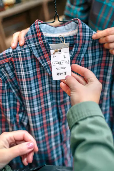 Elbise Mağazasında Tanınmayan Kadın Müşterilerin Ele Tutuşan Ekose Gömlek Etiketlerini Stok Fotoğraf