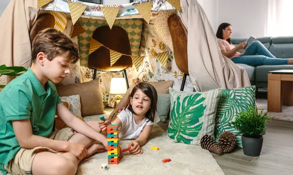 아이와 플레이하는 스태킹 게임의 조각을 행복한 소녀와 소파에 편안한 집에서 로열티 프리 스톡 이미지
