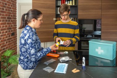 Aile 72 saat hayatta kalma kiti hazırlıyor ve acil durumlar için tıbbi malzeme ve ilaçları evde kontrol ediyor. Anne ve oğul kendi kendine yeterlilik stratejisini organize ediyor, güvenliği ve sağlığı sağlıyorlar..