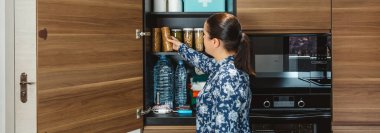 Tanınmayan bir kadın uyarı, öngörü ve kendi kendine yetme stratejisi hazırlıyor. Kadın, dolapta depolanan 72 saatlik hayatta kalma kitine kurabiye paketi ekliyor. Mutfaktaki acil durum yiyecek kilerinde felaketler için.