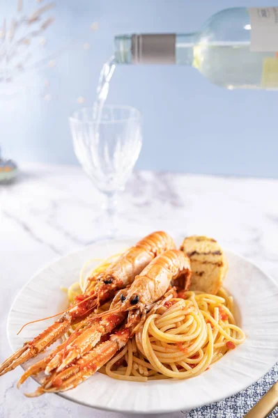 A plate with seafood for the festive table. Pasta with Norwegian lobster and white wine. Food for gourmets. Free space for text.