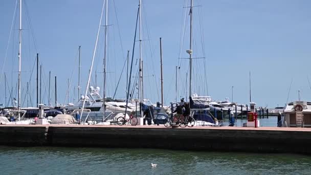 Лодки Удовольствия Пришвартованы Порту Люди Прогуливаются Солнечную Погоду Набережной Курортного — стоковое видео