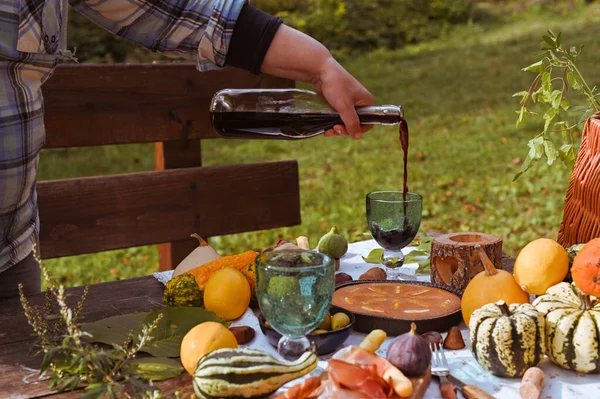 Autumn picnic. Table prepared for lunch in autumn nature, picnic . Harvest, autumn lunch, Wine and glasses. Outdoor meeting