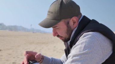 Man on the beach in autumn. A man of European appearance is resting and enjoying the atmosphere of the beach. Close up face. High quality 4k footage