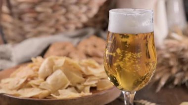 Glass of light craft beer on a wooden table. Beer is poured into a glass with foam and bubbles. for social media or advertising. beer texture. High quality 4k footage. 