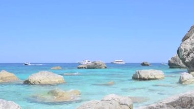 Blue beach in Sardinia. Italian coast, elite resorts. BLUE SKY AND CLEAR WATER and white small stones. High quality 4k footage. Vertical