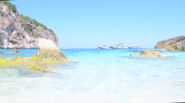 Blue beach in Sardinia. Italian coast, elite resorts. BLUE SKY AND CLEAR WATER and white small stones. High quality 4k footage. Vertical