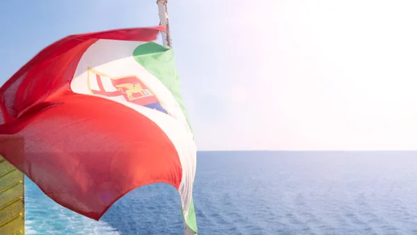 The italy flag flutters in the wind. The symbol of italy on board a ship at sea. High quality FullHD footage . Vertical